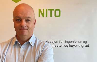 Nils Håheim-Saers foran en NITO-plakat.
