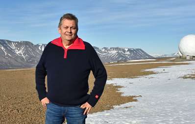 Trond Markussen på Svalbard med fjell i bakgrunnen. 