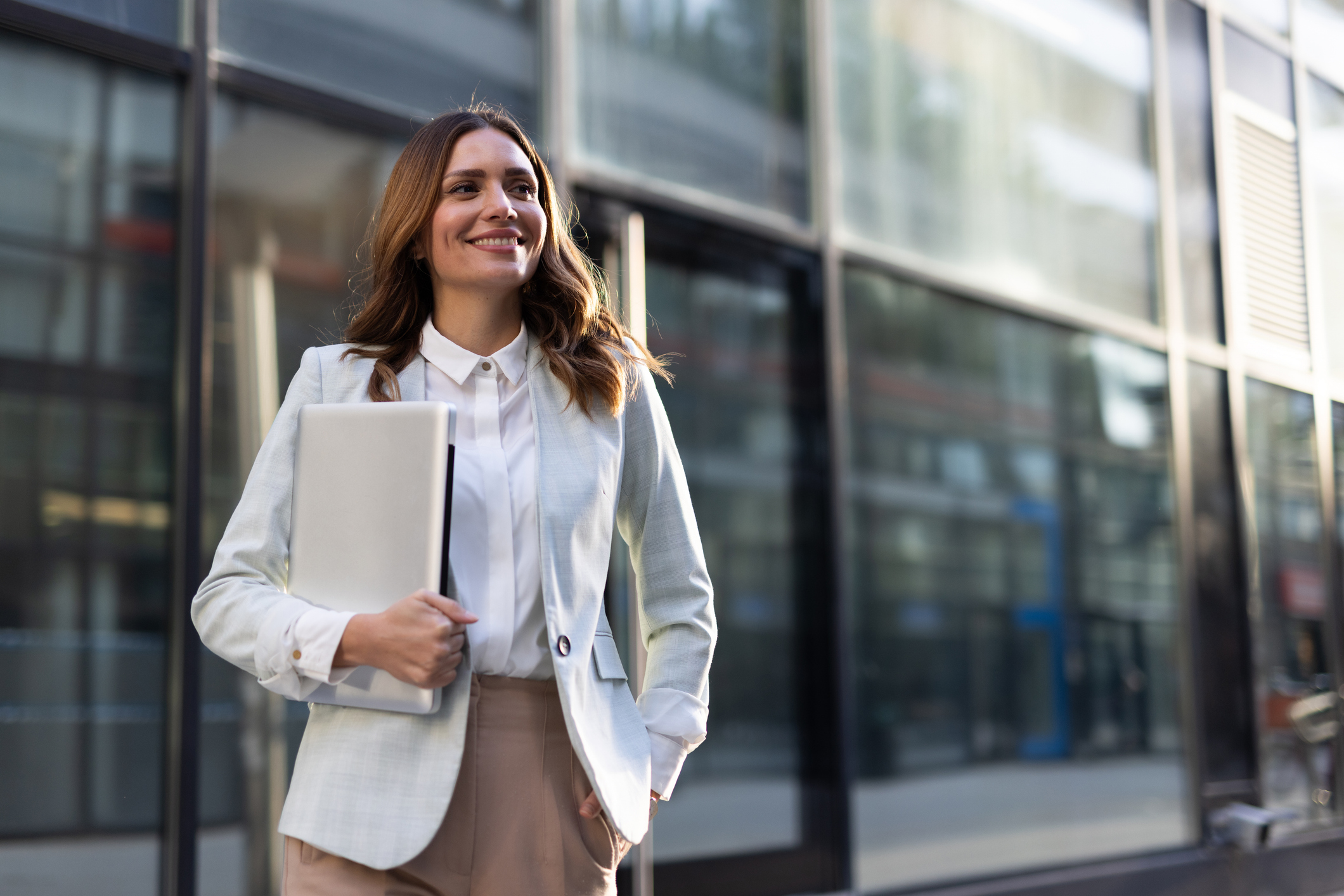 Kvinne som går med med pc i armene 