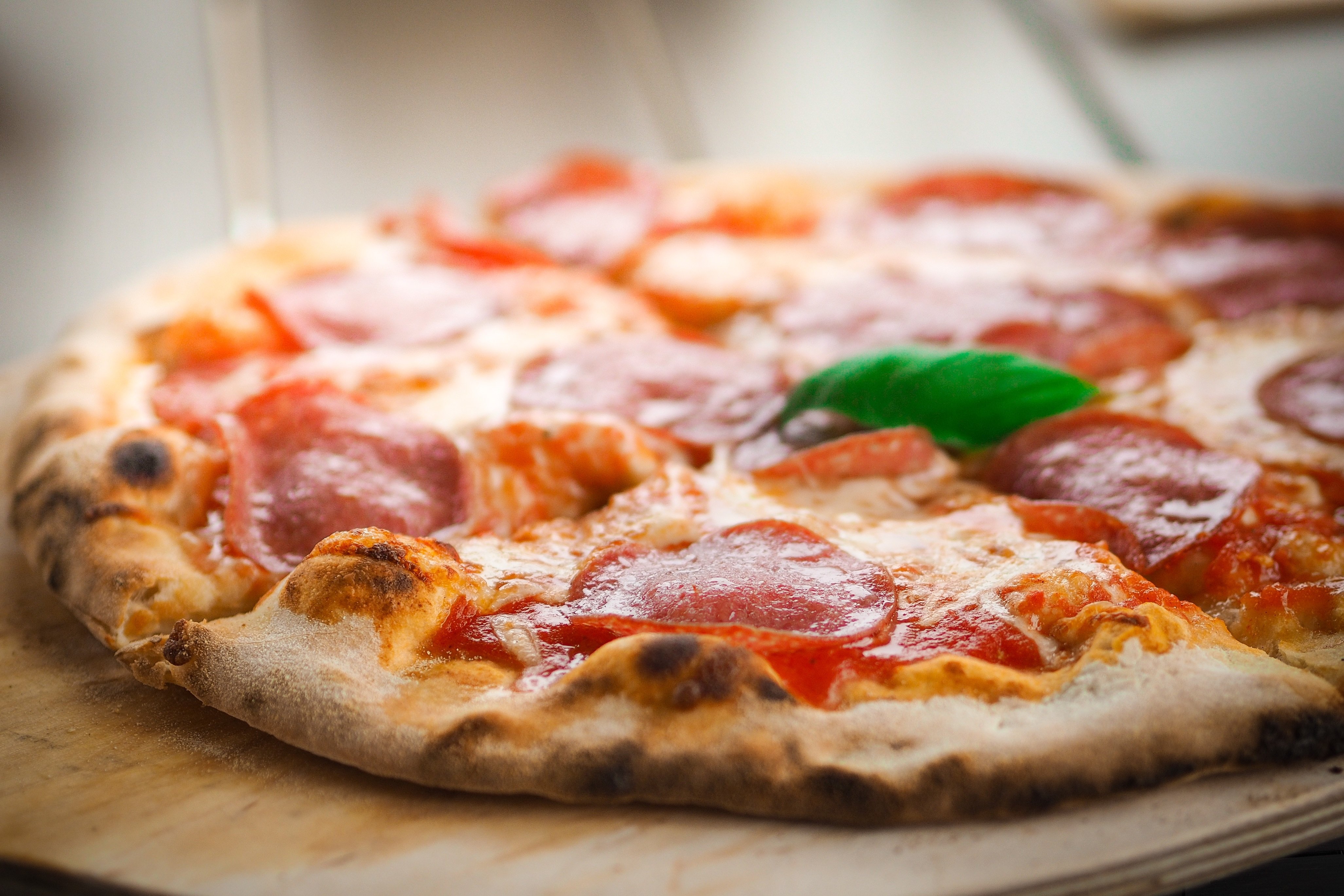 Pizza pepperoni på trefjøl. Image by Andreas Riedelmeier from Pixabay.