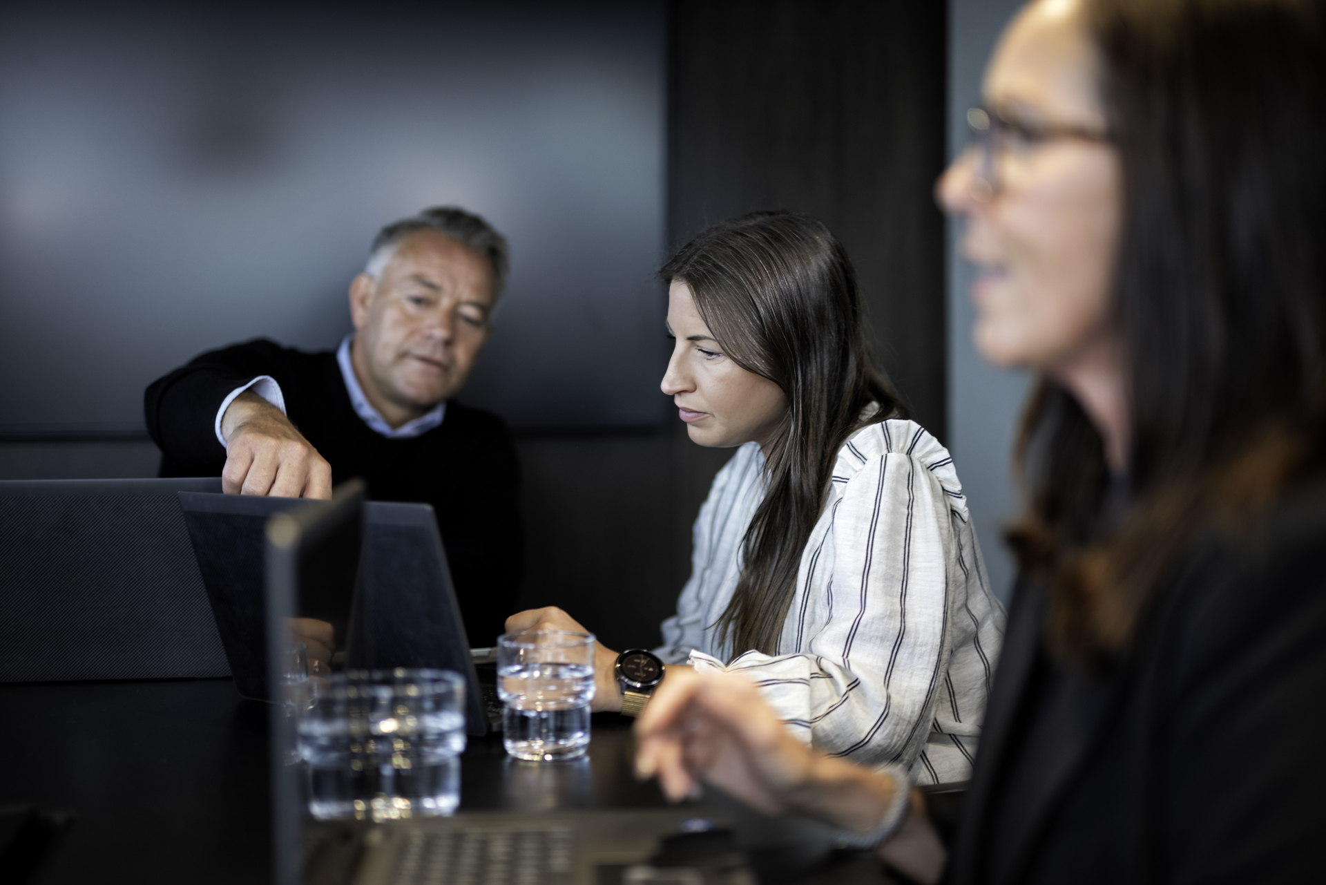  En gruppe ansatte og ledere snakker sammen i et møterom på arbeidsplassen