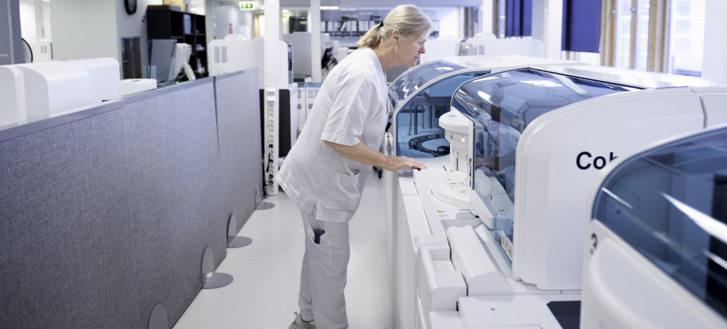 A person operates an advanced laboratory machine in a modern scientific environment