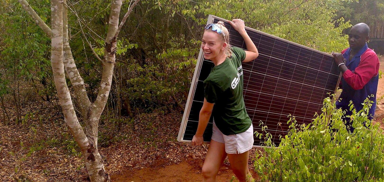 En lokal person sammen med en fra Ingeniører Uten Grenser jobber med solenergi