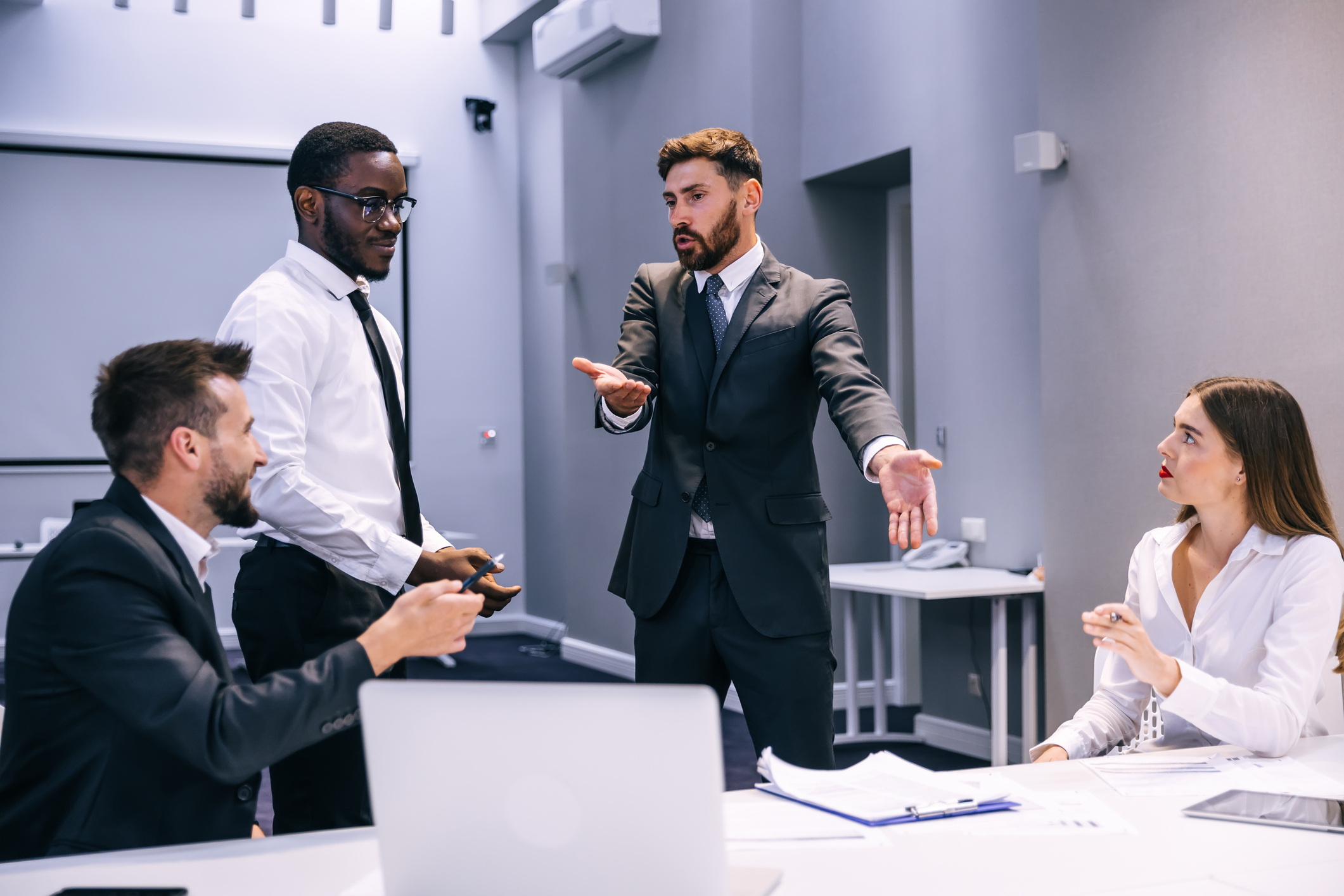 To personer som diskuterer med frustrert kroppsspråk.