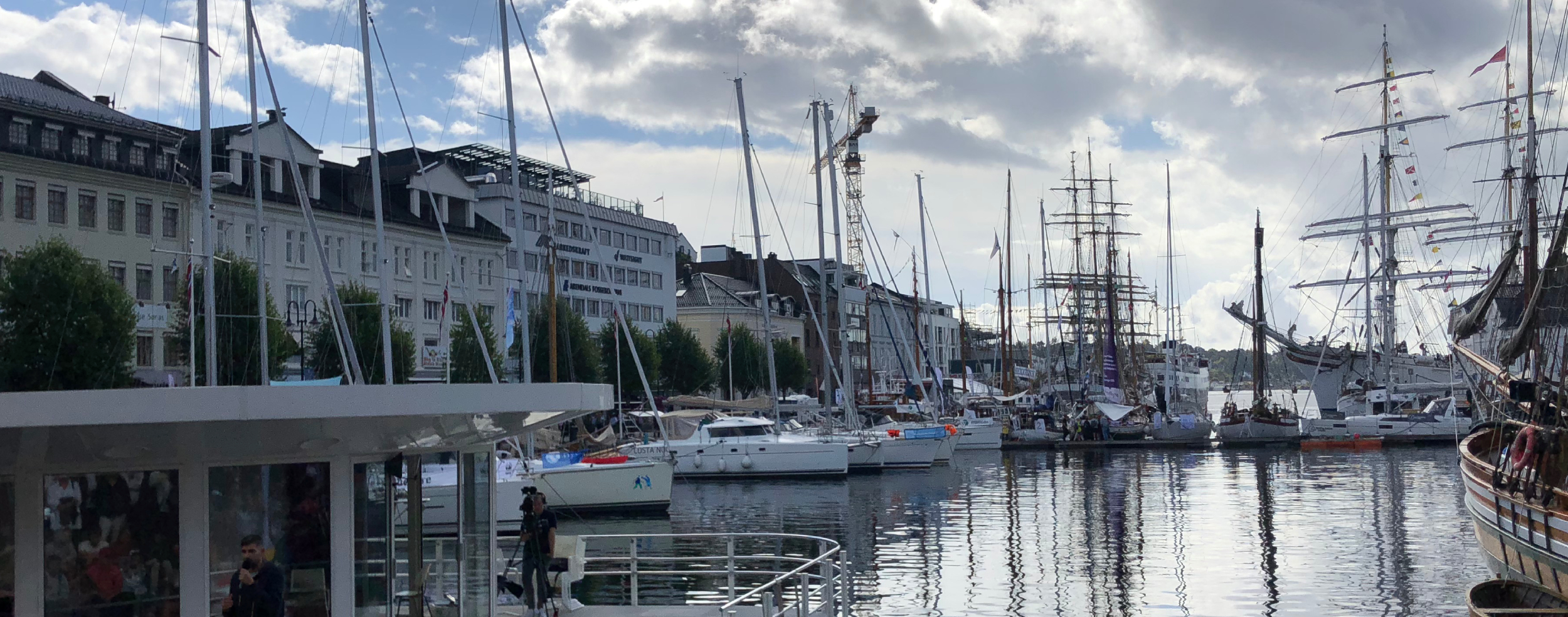 Bildet viser Pollen i Arendal under Arendalsuka, med seilbåter og folk langs kaia.