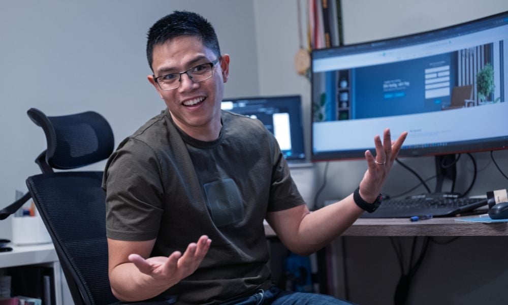 John-John som veiver med armene foran en dataskjerm. 