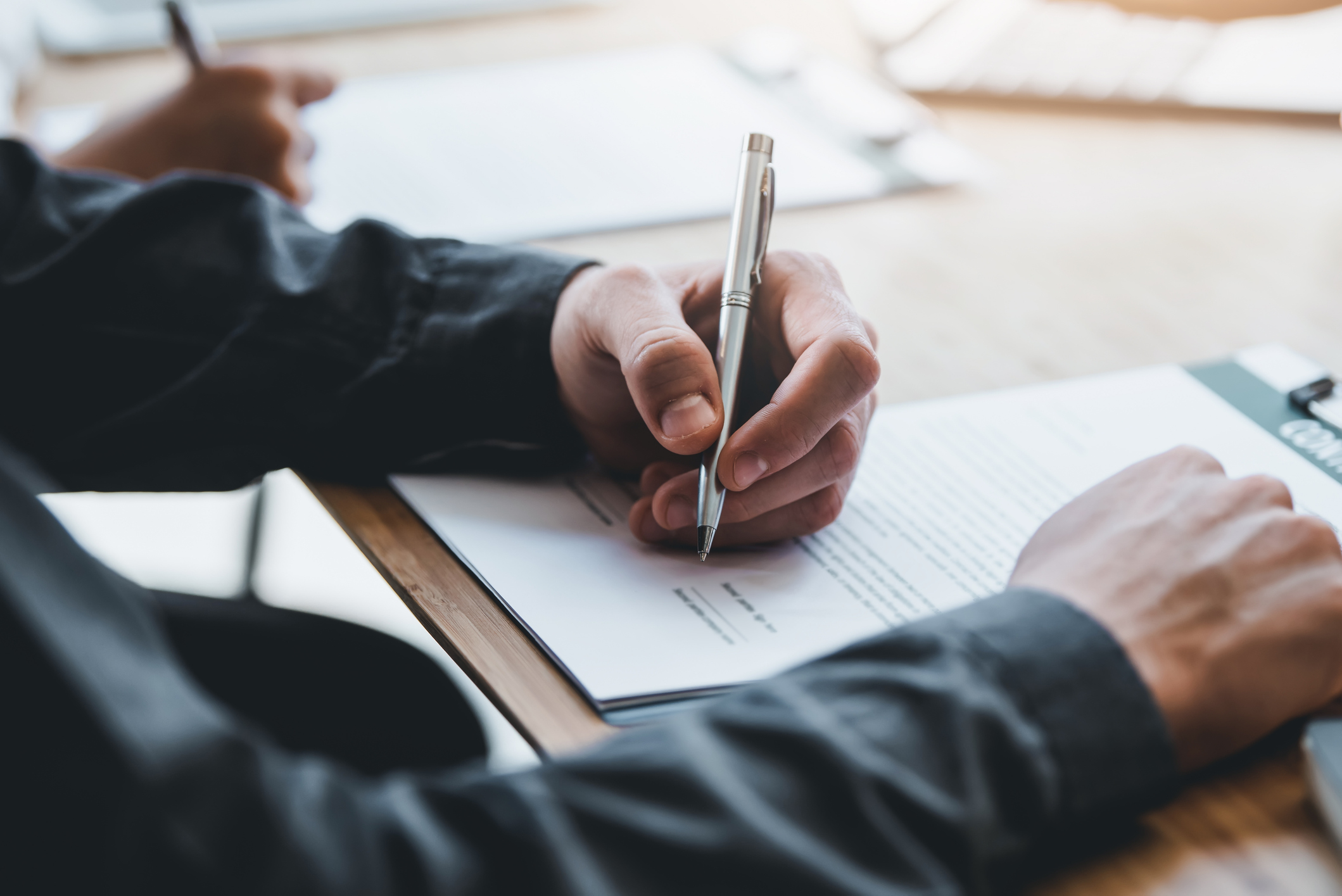 Illustrasjonsbilde: Ser hender som holder penner og skriver under på papirer