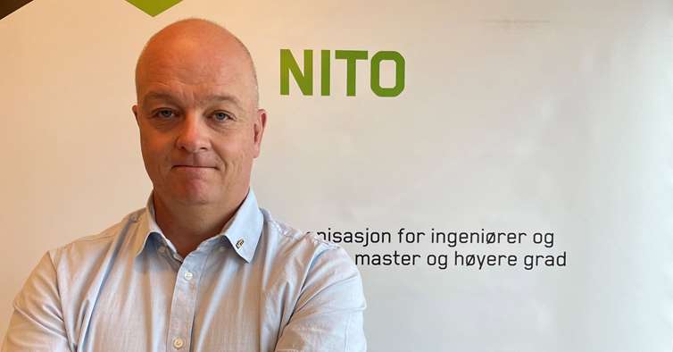 Nils Håheim-Saers foran en NITO-plakat.