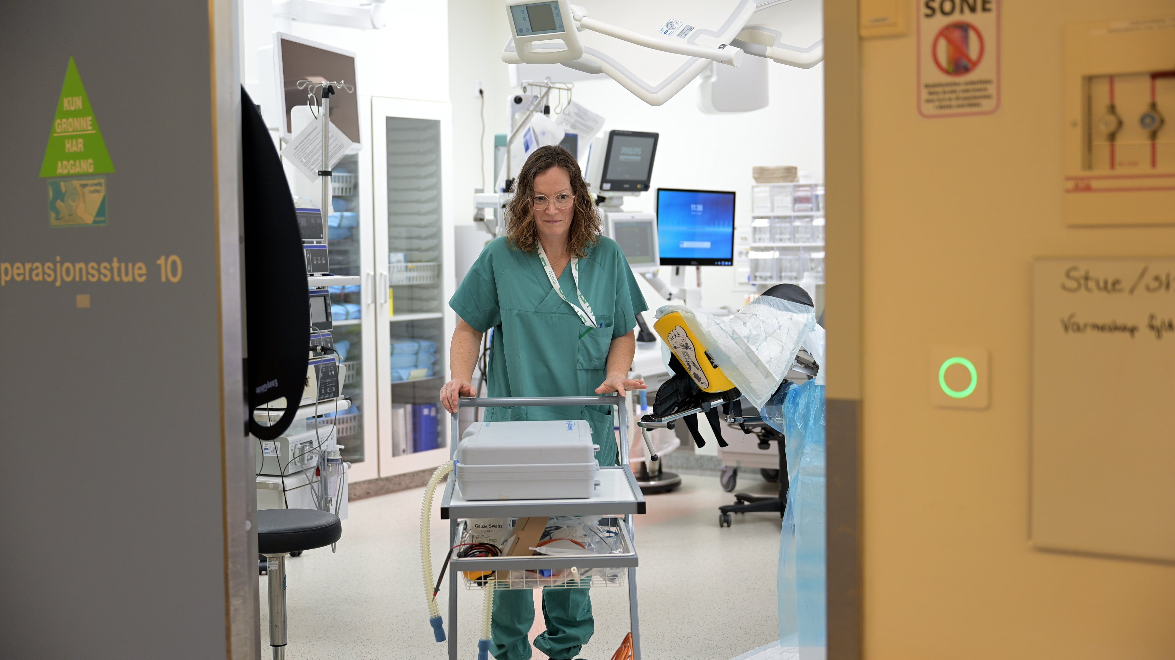 Woman walks out of operating room with technical equipment
