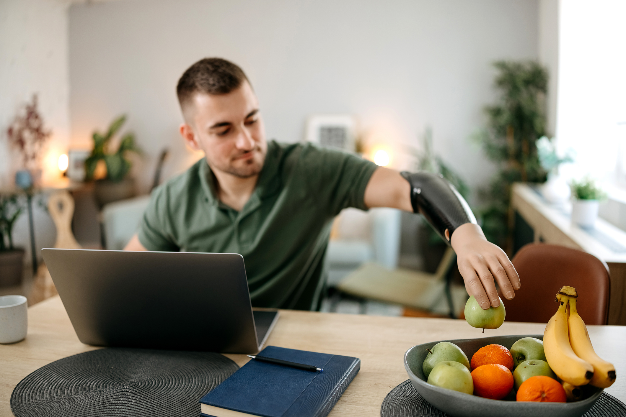 Man with prosthetic arm working on laptop