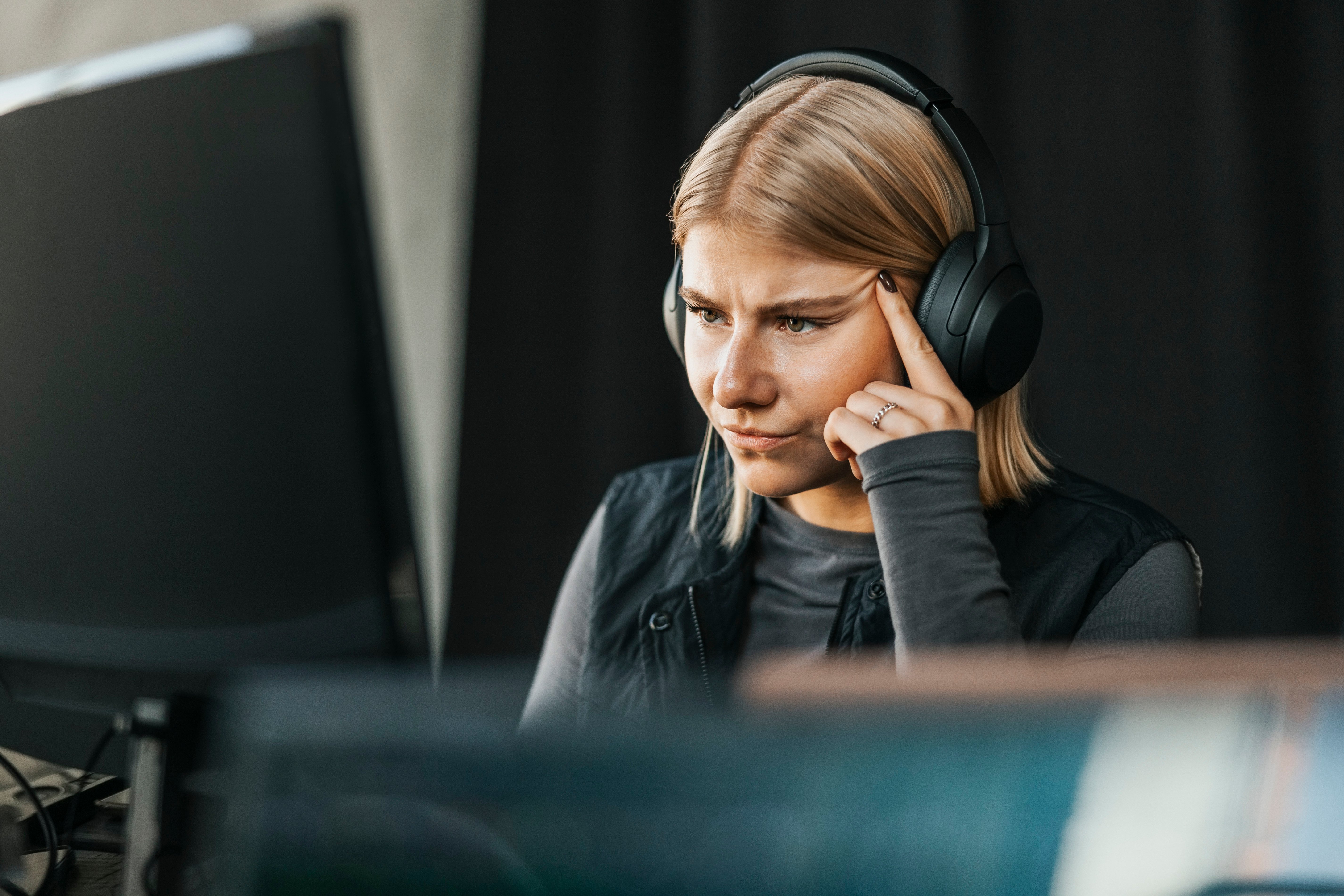 Ung dame som ser på en PC og har på headset