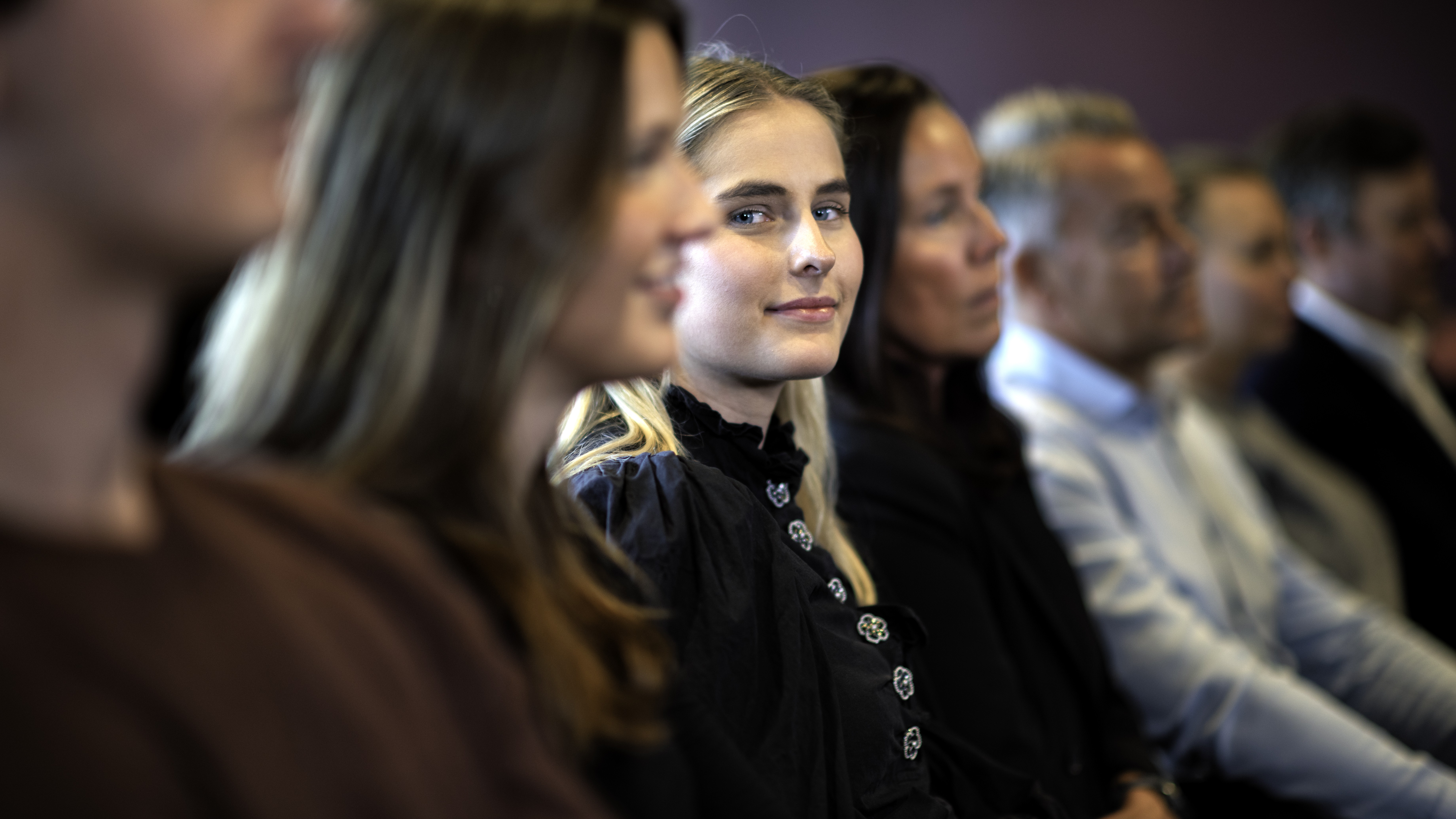 Ung kvinne, kursdeltaker, ser og smiler mot kamera 