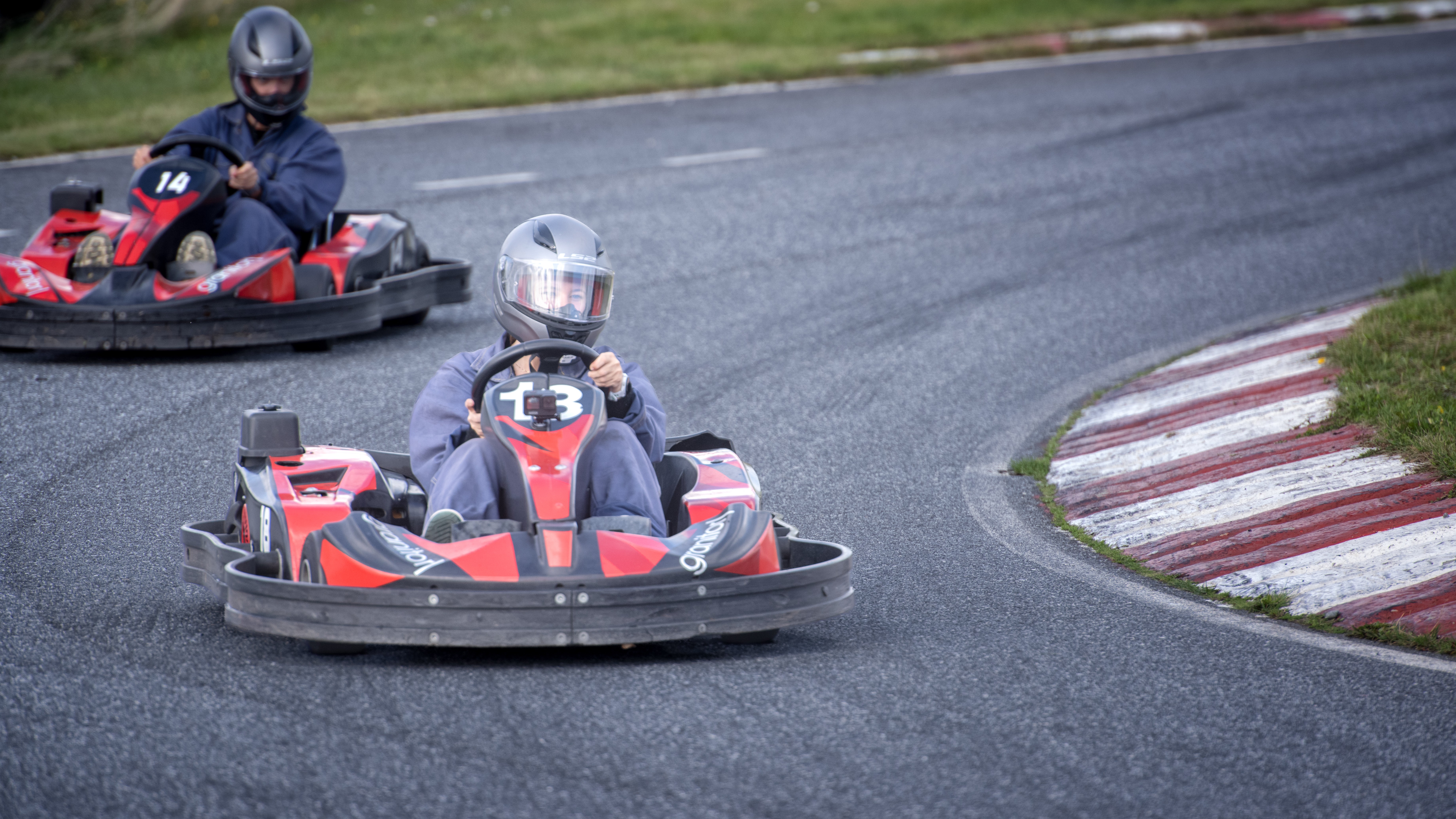 To personer som kjører gokart i hver sin bil 