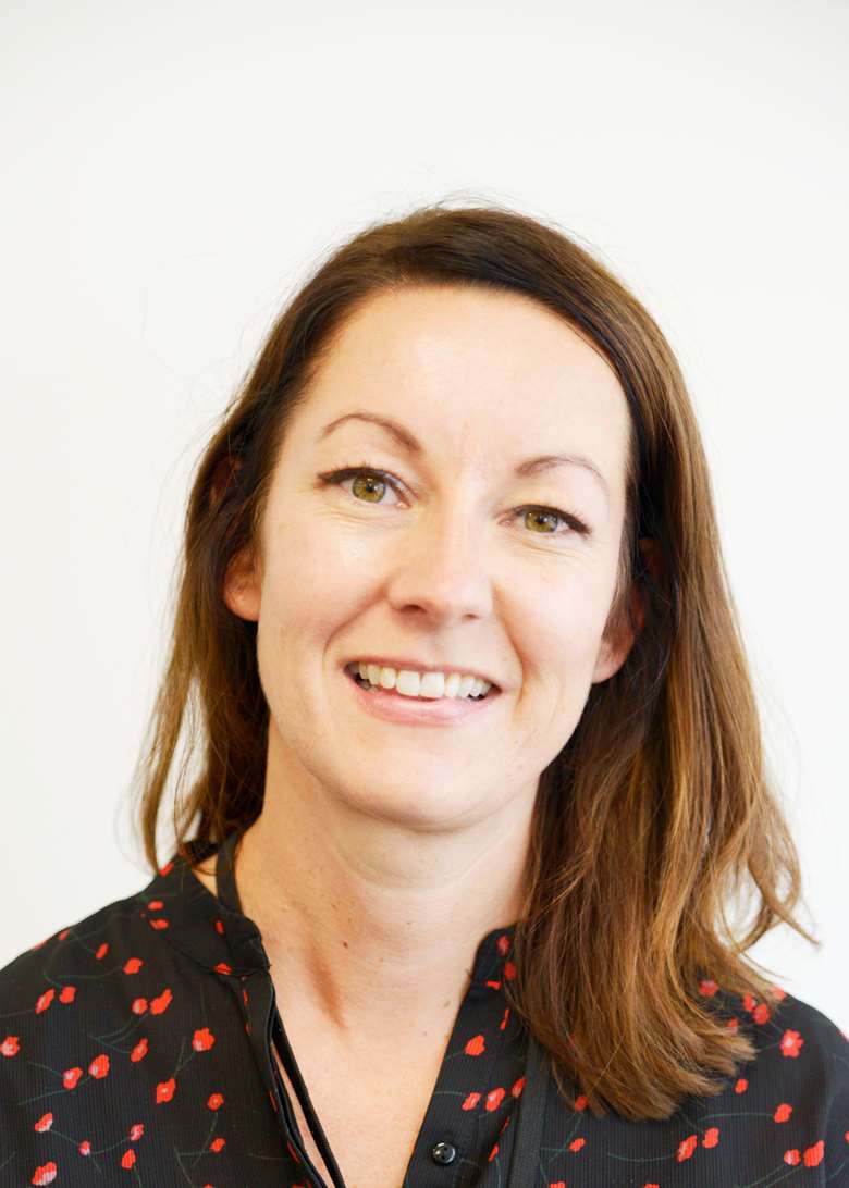 Portrett av smilende kvinne med langt mørkt hår.