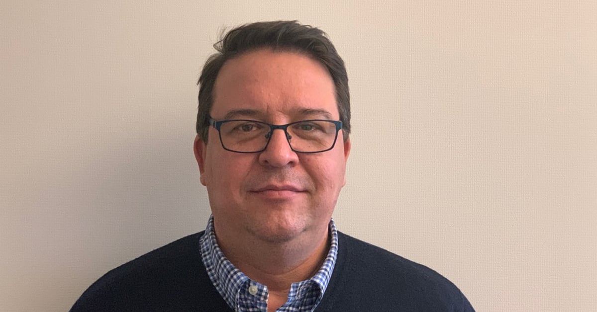 Portrett av mann med briller, rutete skjorte og mørk genser