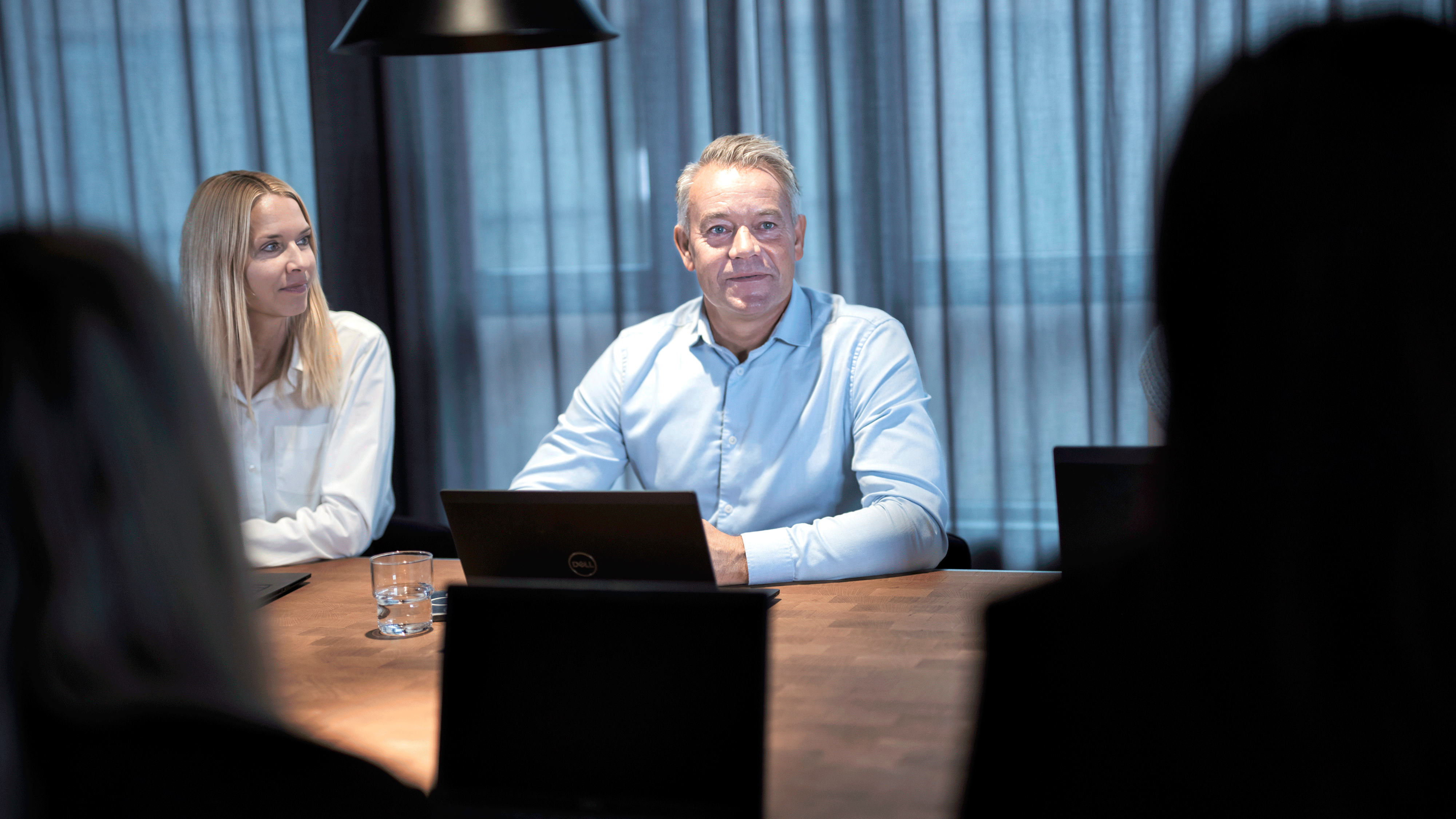 Tillitsvalgte og arbeidsgivere sitter rundt et bord i forhandlinger, som symboliserer kampen for lønnsøkning i privat sektor.