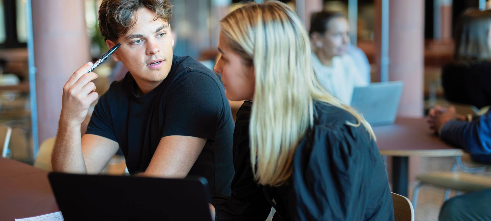Two students - a boy and a girl - sitting in a reading room