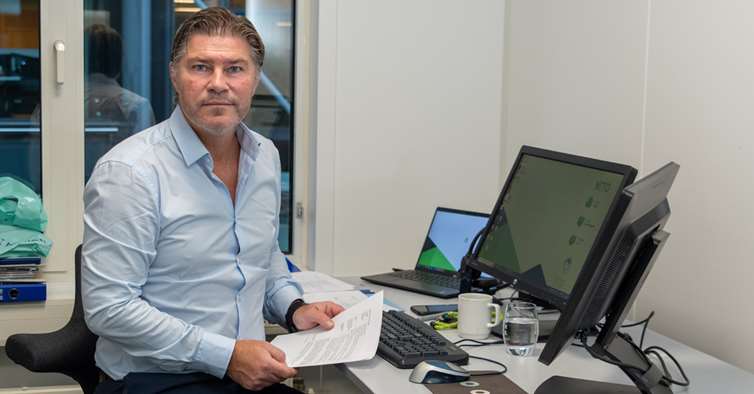 Steinar Andersen med papirer i hendene på kontoret. 