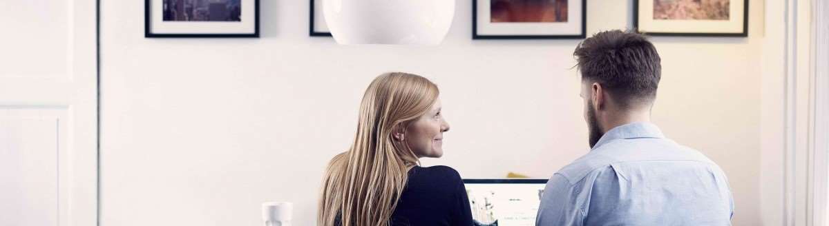 Ungt par ser på laptop og vurderer å bli Premium Next-kunde. Foto:Nordea