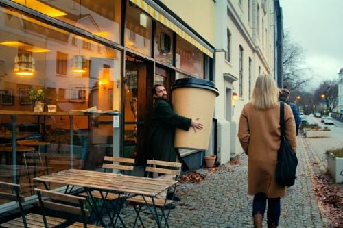 En mann bærer på en enorm kopp med kaffe. Reklame for NextGenTel - du får mye mer enn du tror