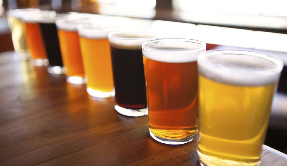 Øl av ulik variasjon stående på en bardisk