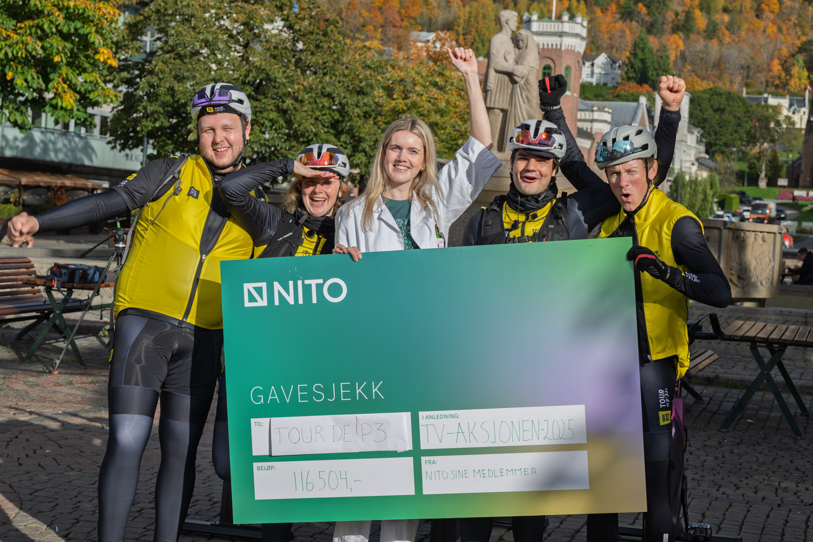 Bildet viser deltakerne fra Tour de P3 som får utdelt en sjekk av NITO.