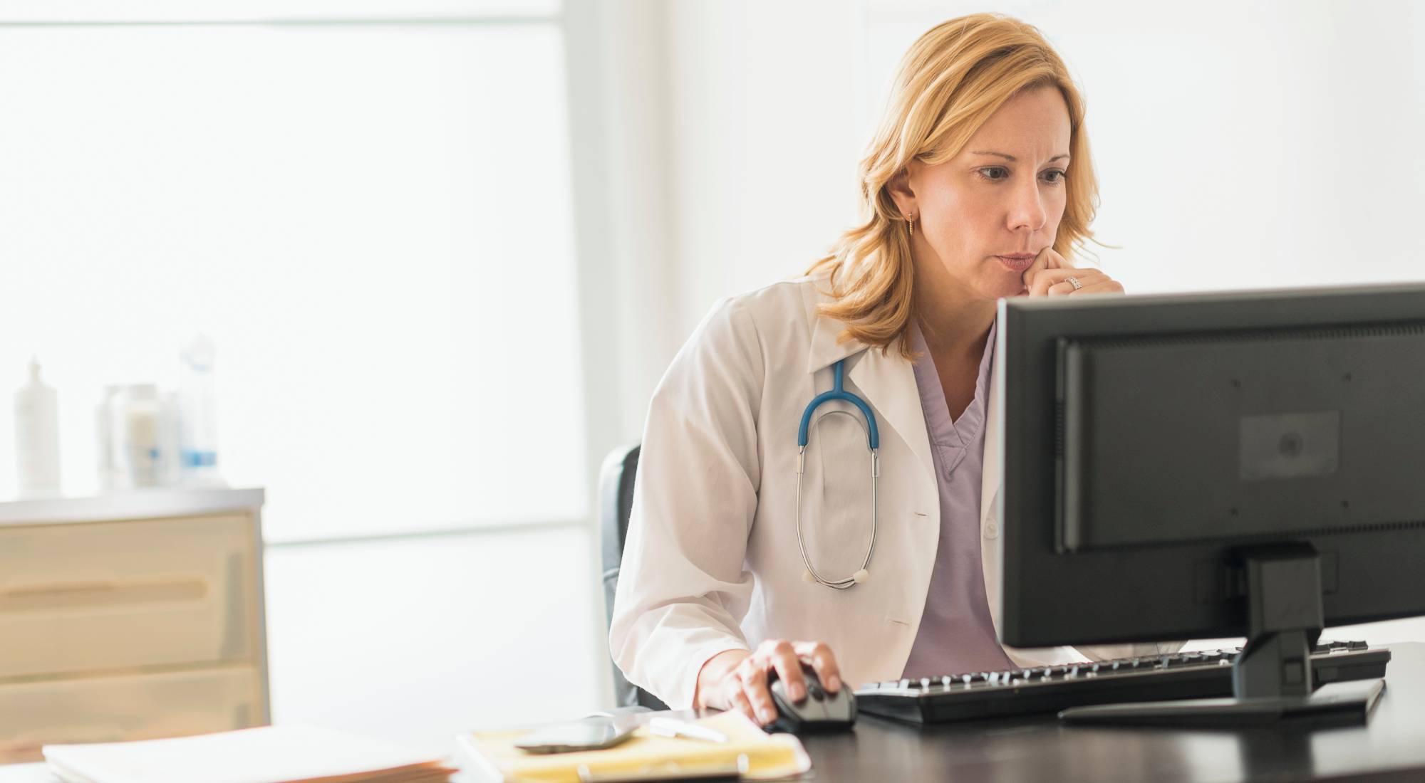 Female doctor sitting in front of a computer screen. Photo: Gettyimages