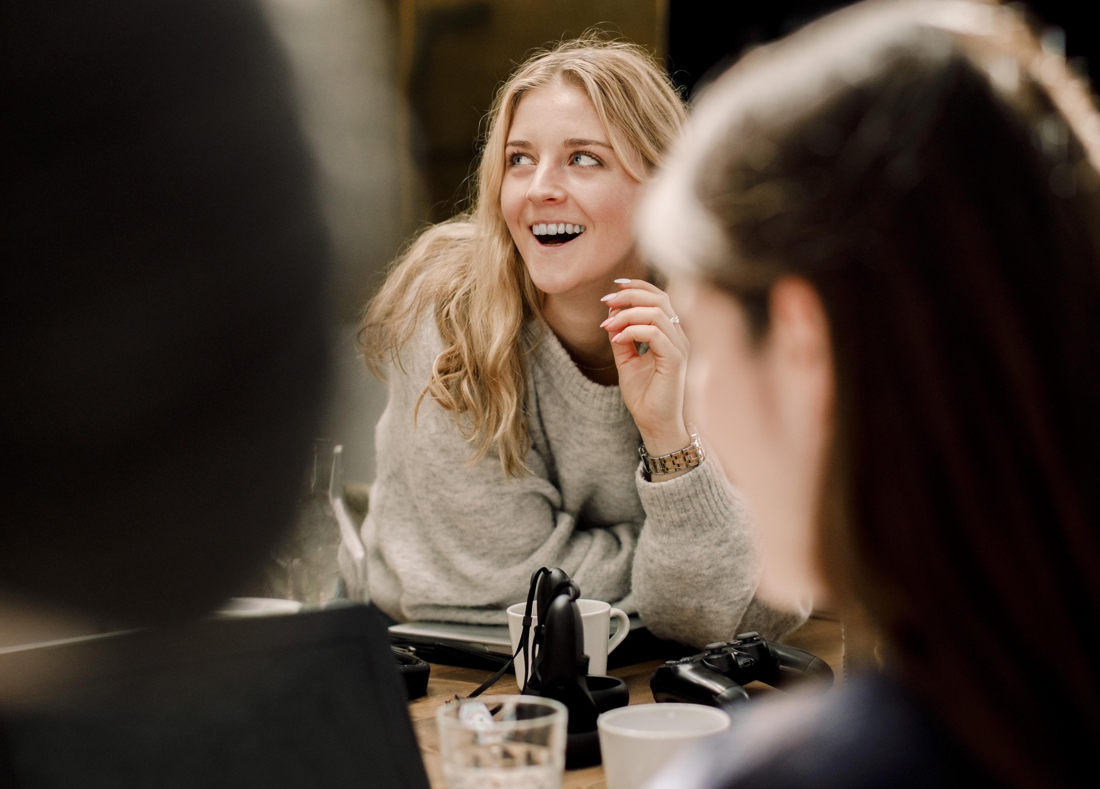 A young, female union representative sits among other union representatives on a course, she smiles broadly.