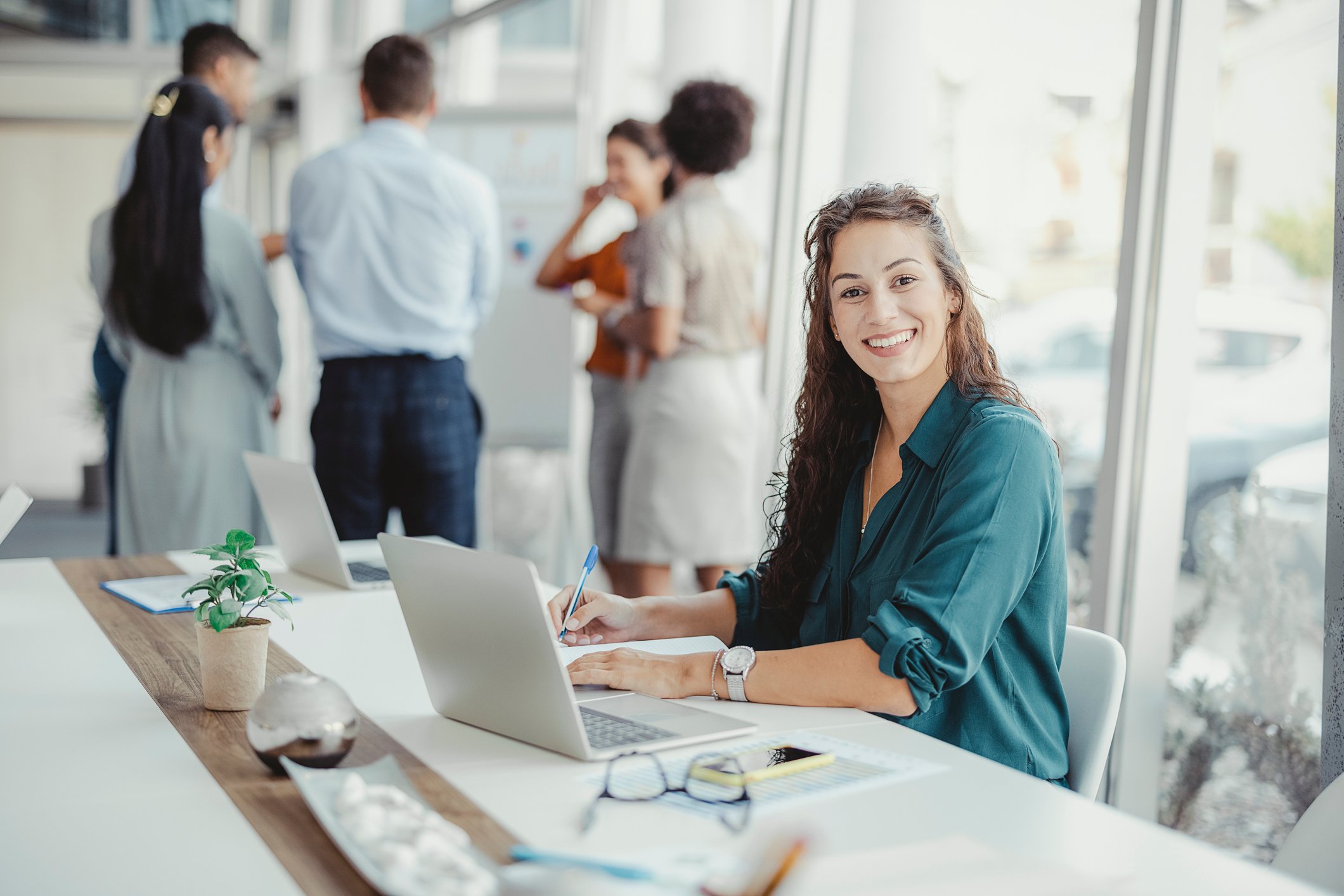 Kvinne i en prosjektgruppe som smiler.