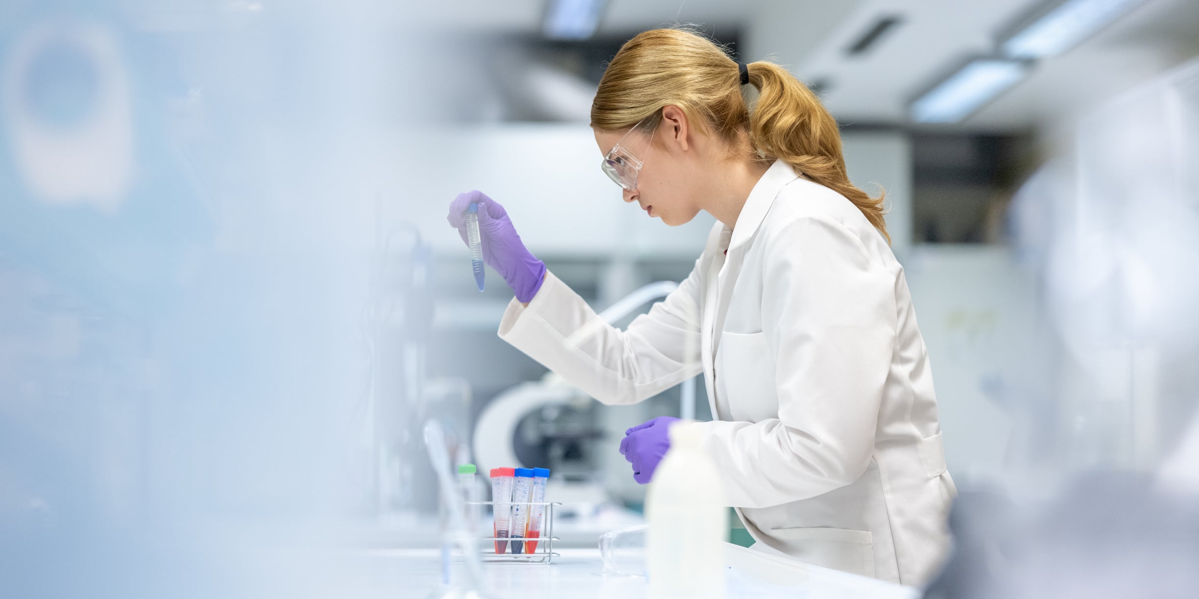 A woman analyzing a sample in a laboratory
