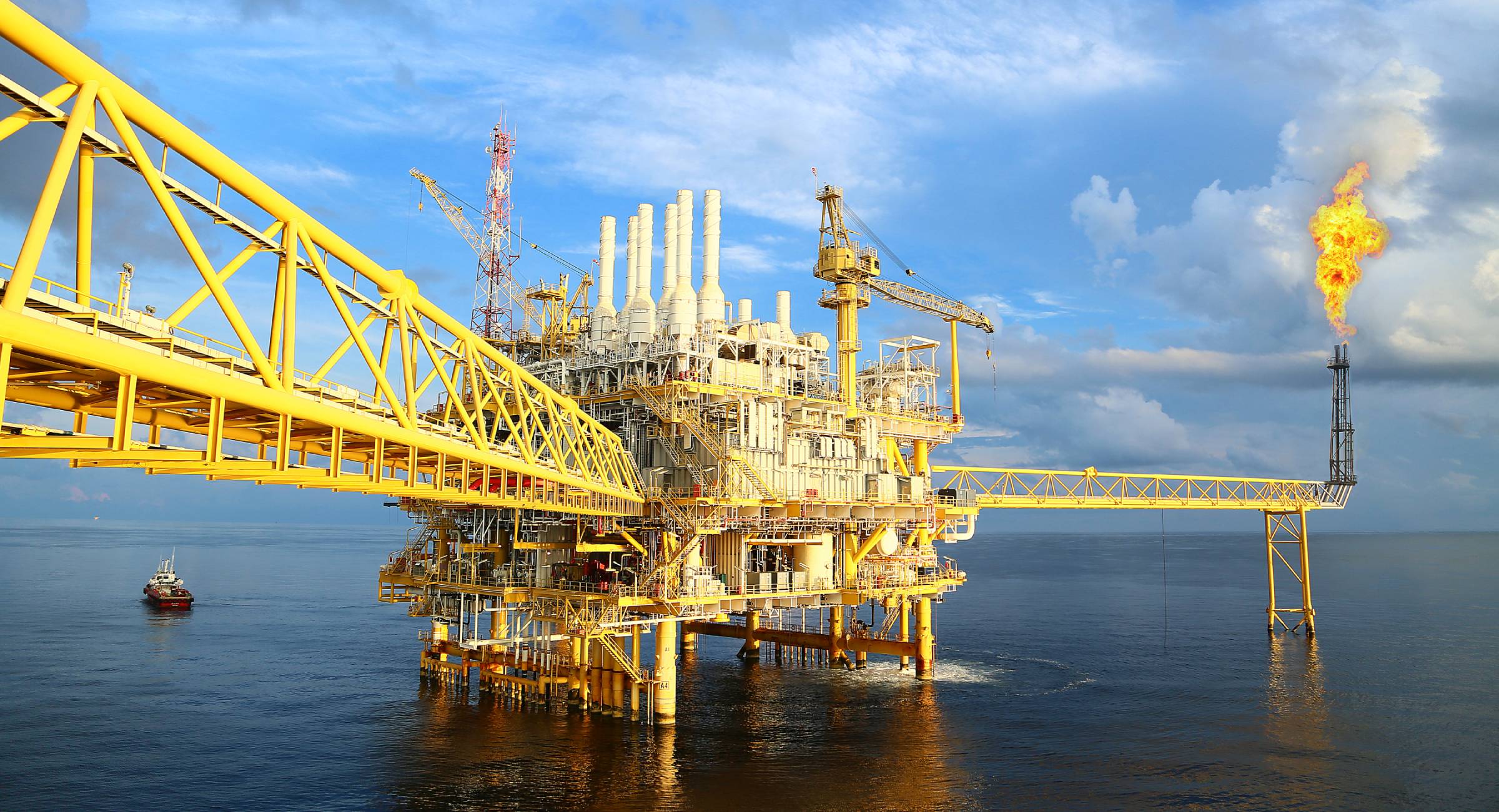 Picture of an oil platform. Sunshine, blue skies and blue sea.