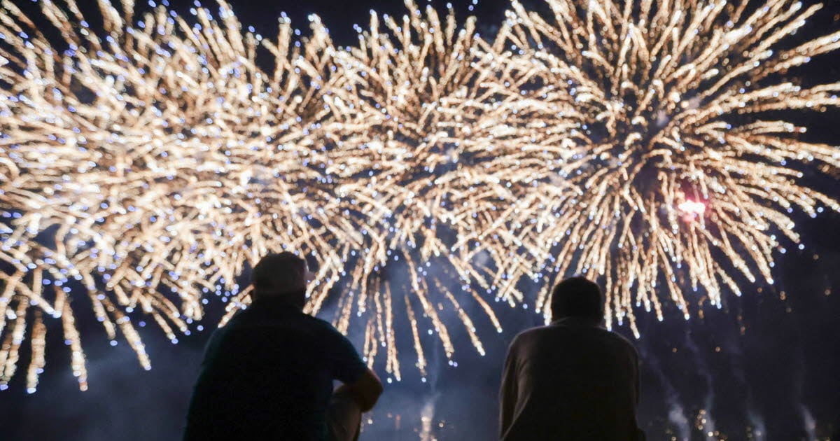 silhuett av to mennesker som ser på nyttårsrakketter