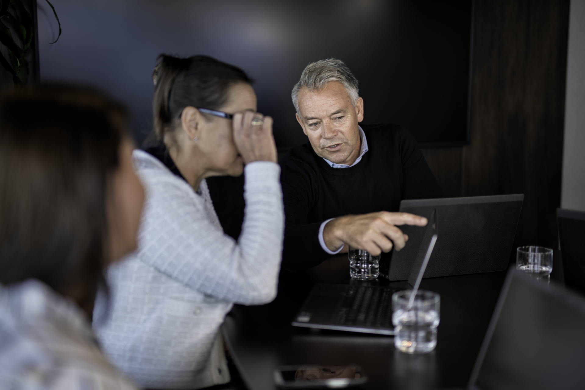 En mann peker p&aring; en datamaskin og hjelper en kvinne.