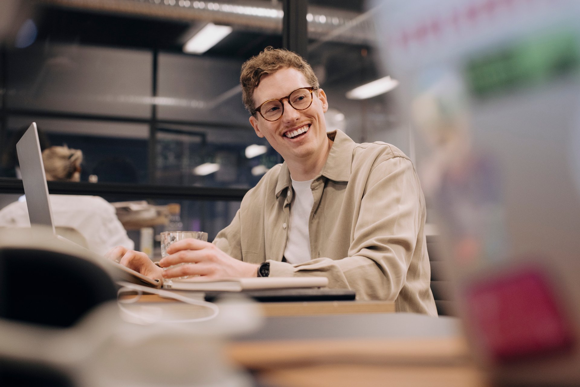 Ung mann med briller ved laptop