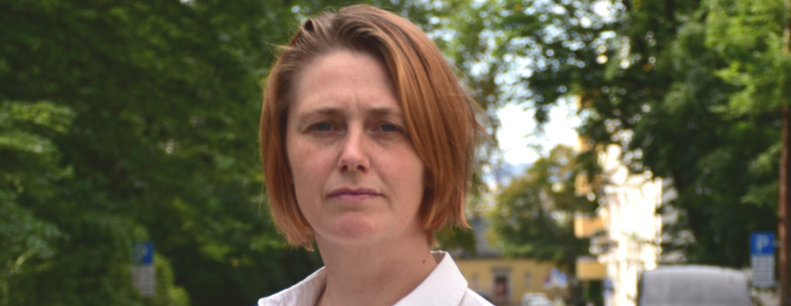 Portrett av kvinne, med biler og trær i bakgrunnen