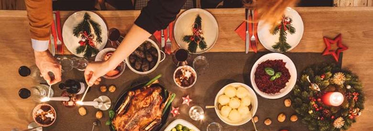 Et bord med julemiddag og hender som forsyner seg. Foto: Getty Images