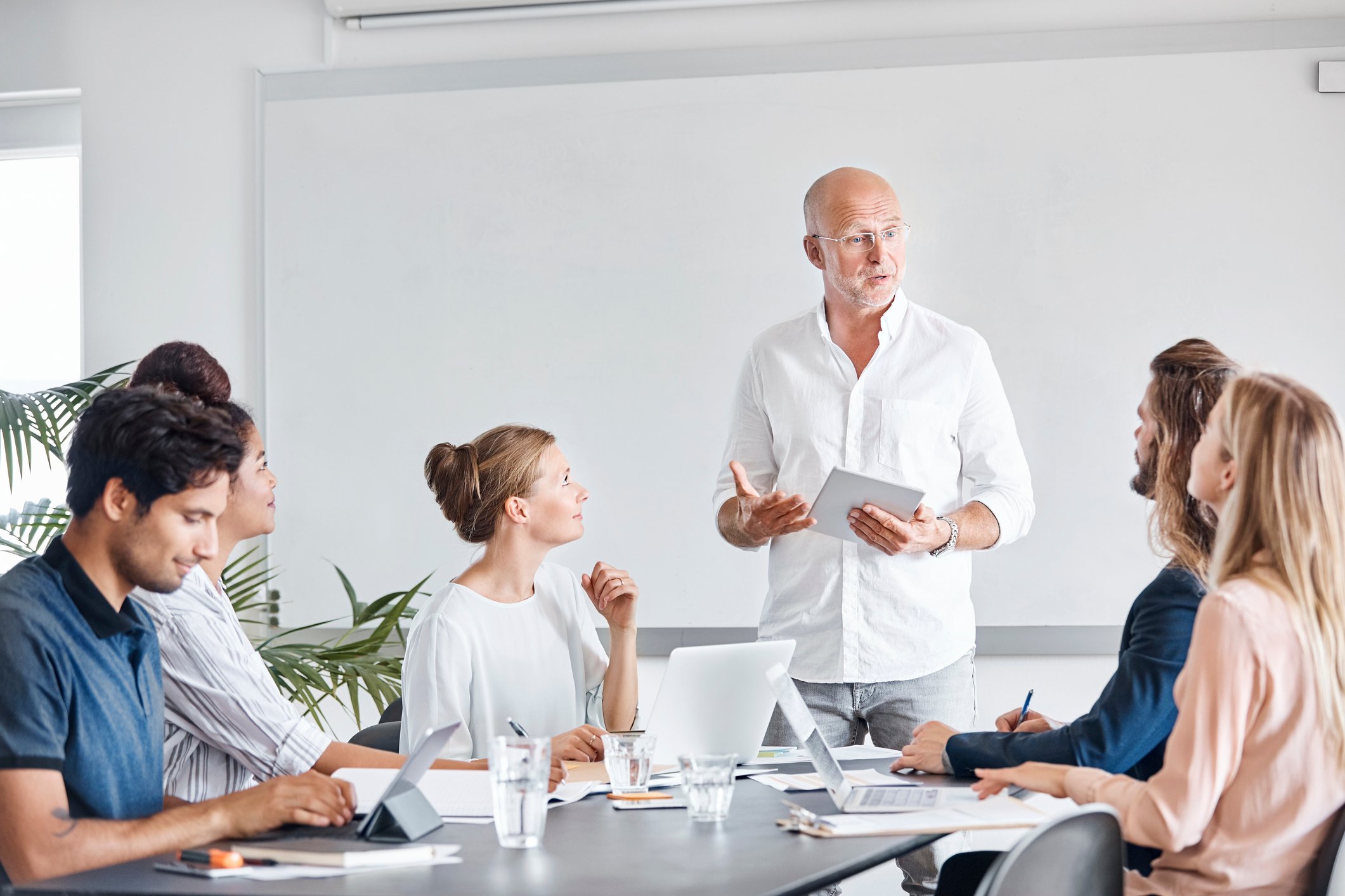 Et team samarbeider rundt et møtebord i et lyst, moderne kontor