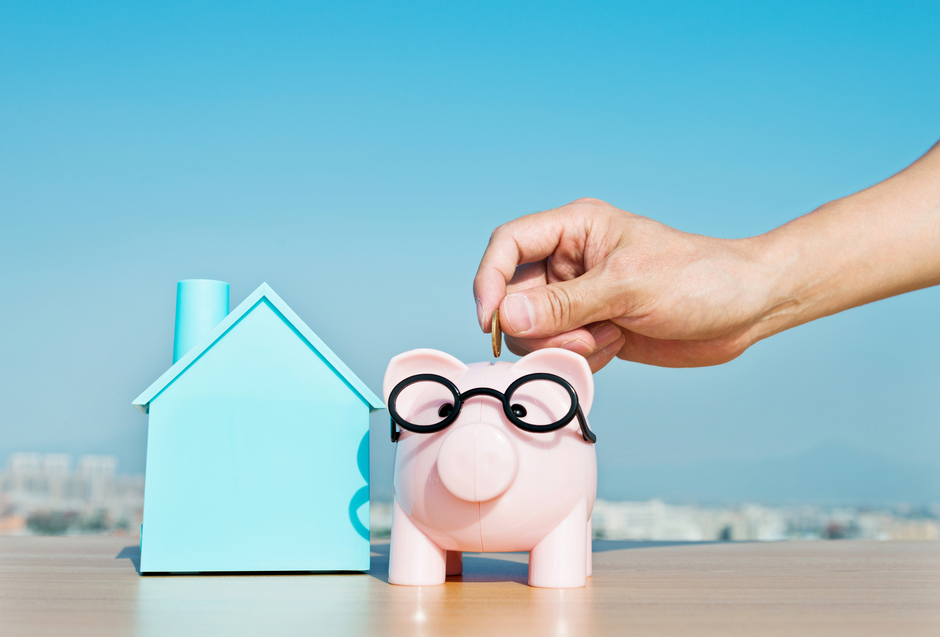 Illustrasjonsbilde av noen som putter penger på en sparegris