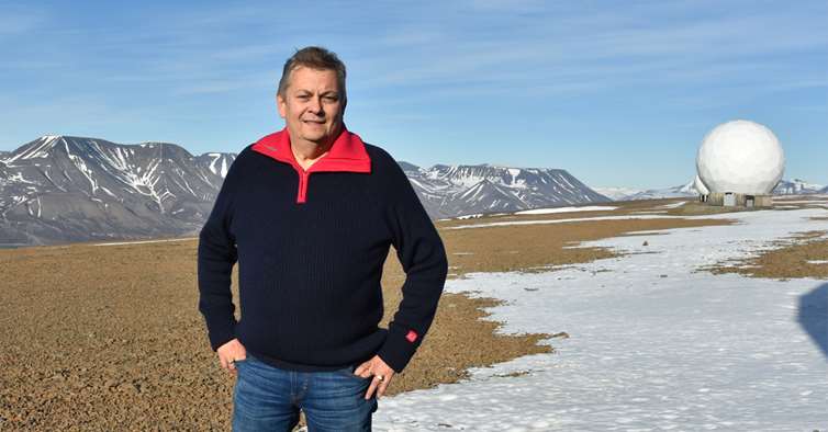 Trond Markussen på Svalbard med fjell i bakgrunnen. 