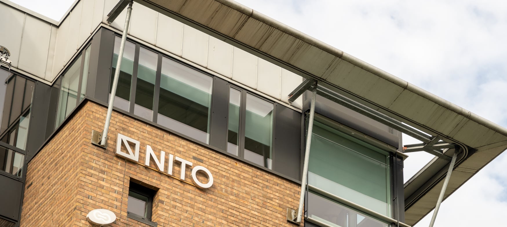 Bilde av en fasade til et kontorbygg med NITO-logo på veggen