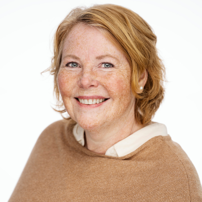 Portrett av smilende kvinne med brunt hår og brun genser