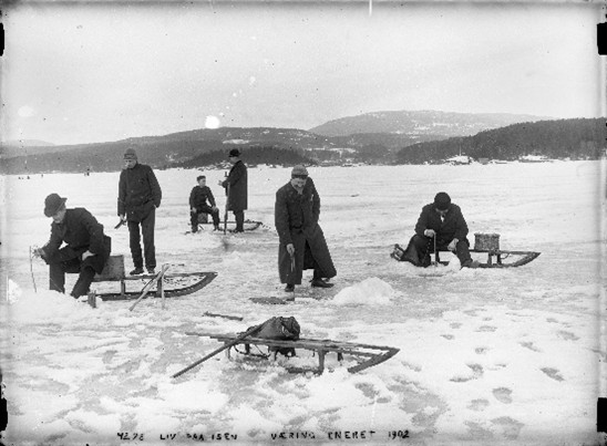 svarthvitt bilde av 6 menn som isfisker på Oslofjorden