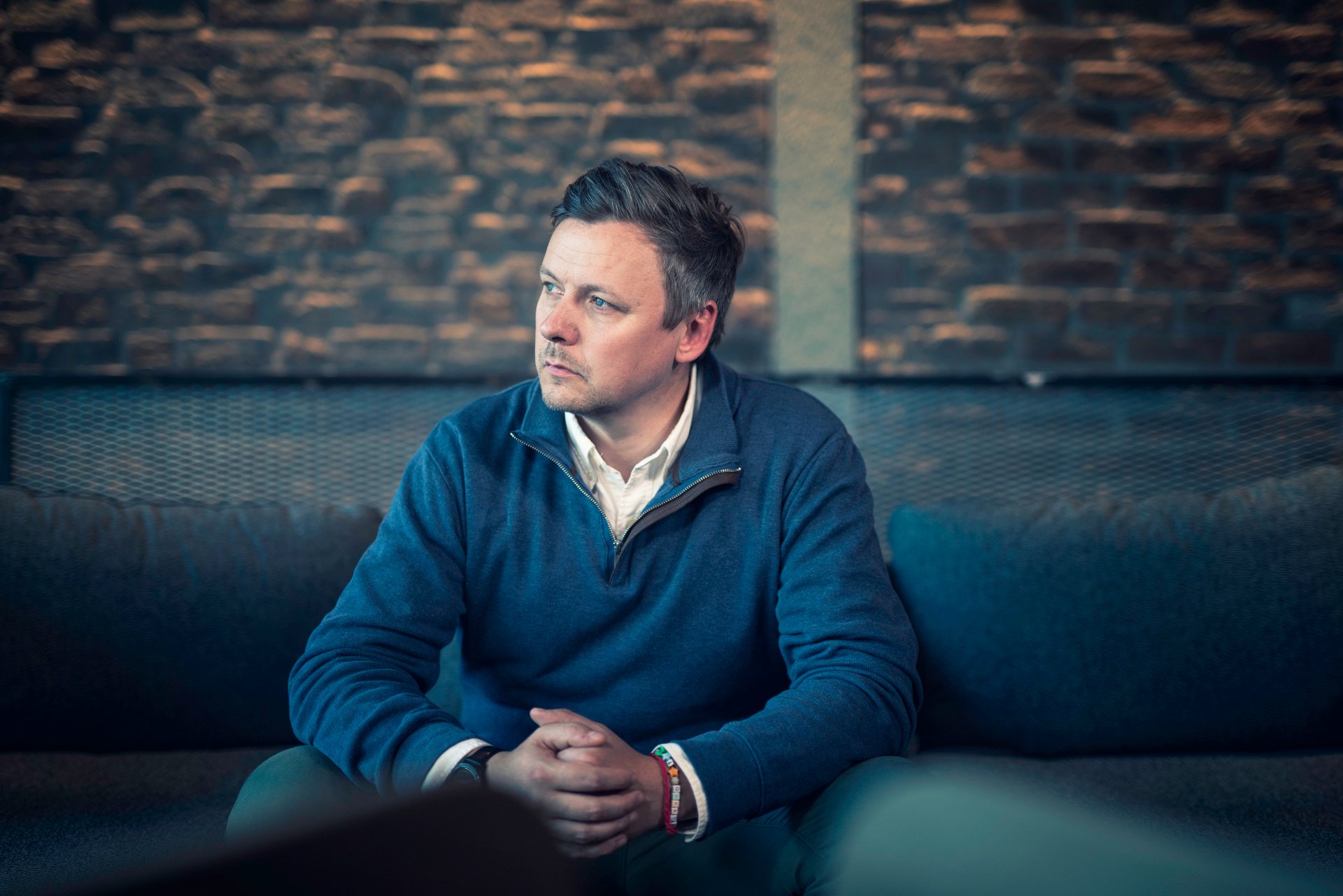 Mann som sitter på sofa med bekymret uttrykk