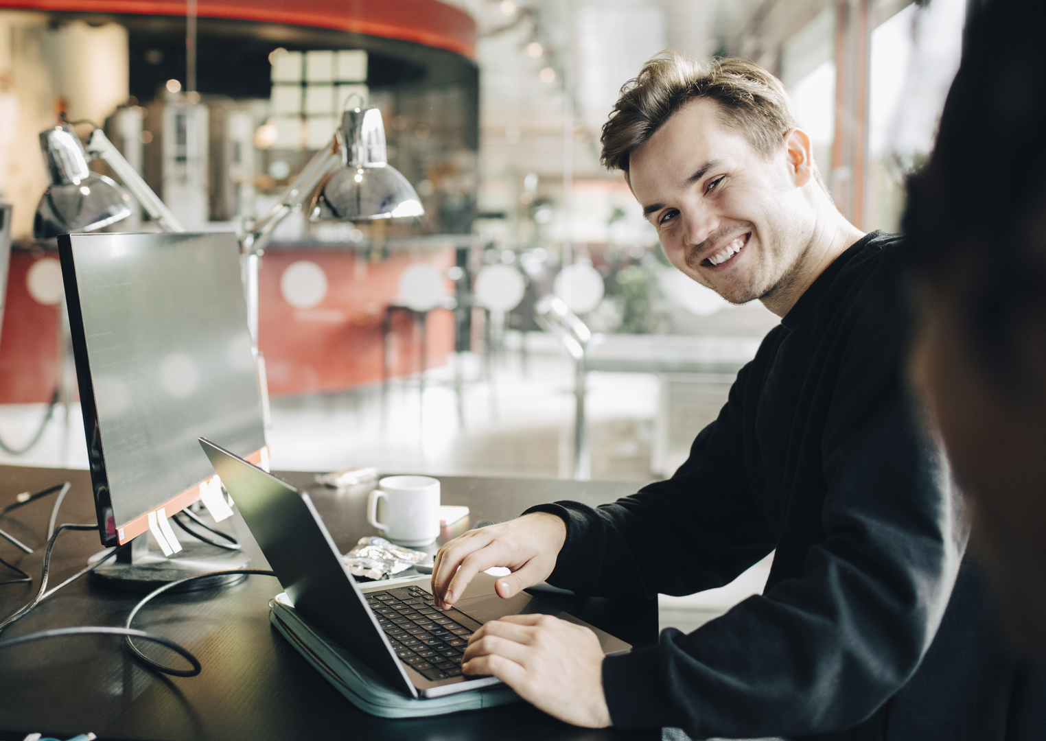 En smilende tillitsvalgt jobber med lokale forhandlinger på sin laptop, som symboliserer vellykkede lønnsøkninger.