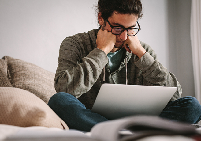 Person ser ned på sin pc