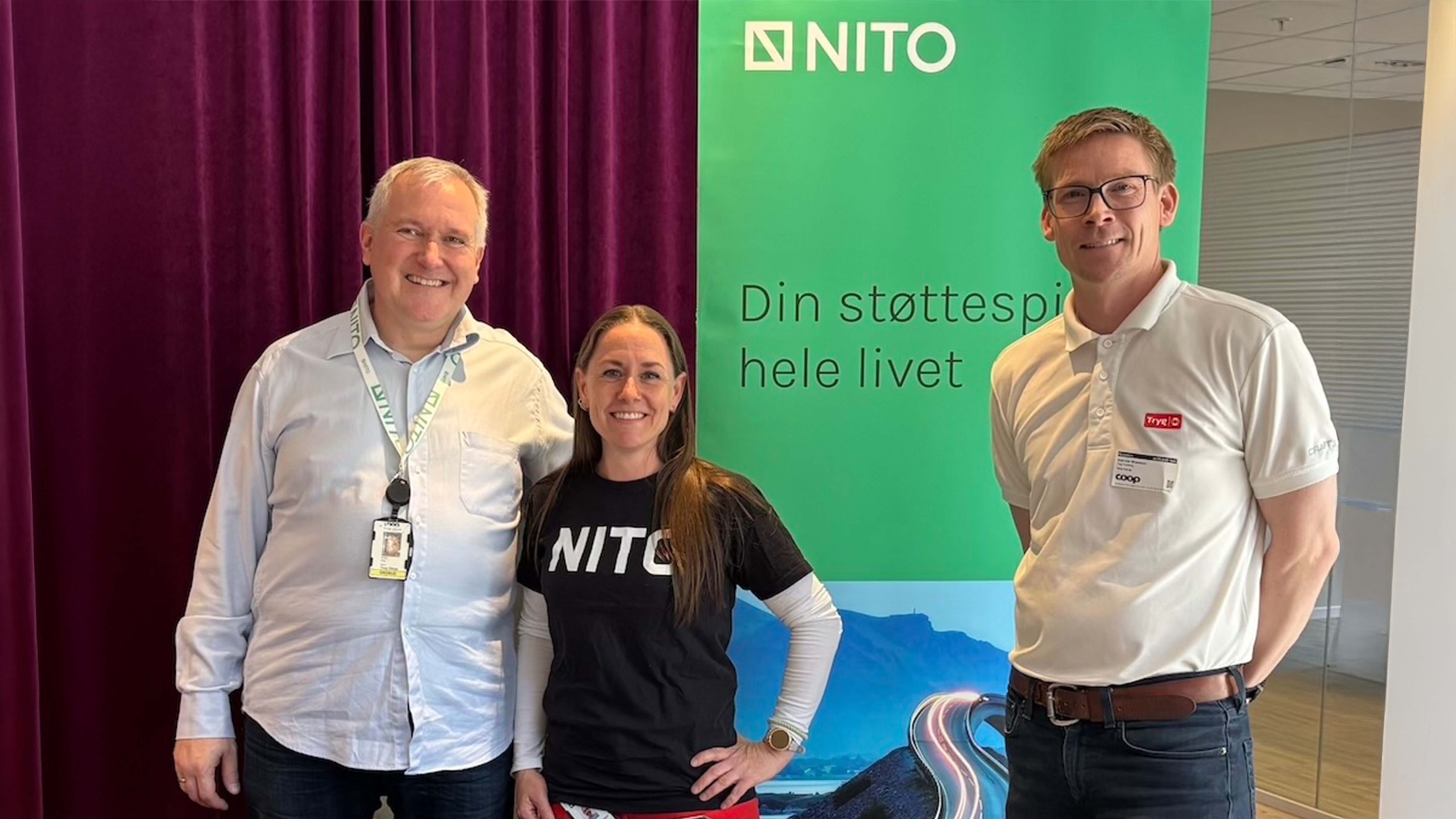 Three people stand smiling and look into the camera